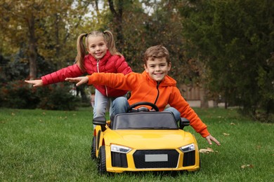 Cute children playing with toy car in park