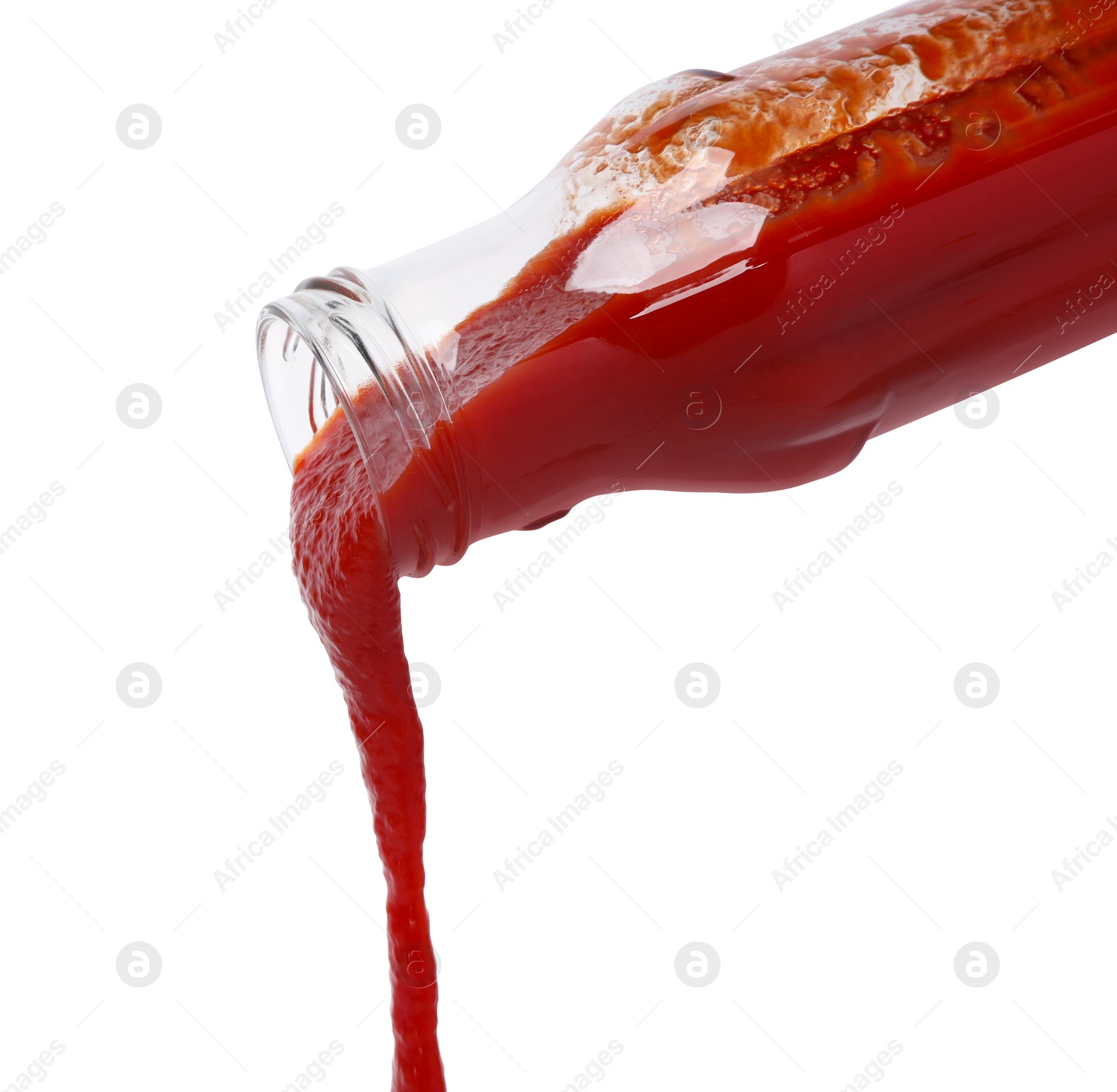 Photo of Pouring tasty red ketchup from glass bottle isolated on white