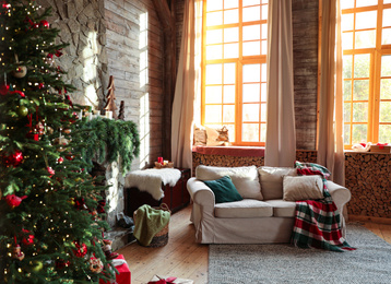 Photo of Festive interior with comfortable sofa and decorated Christmas tree