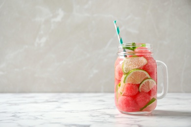 Tasty refreshing watermelon drink on marble table against grey background. Space for text