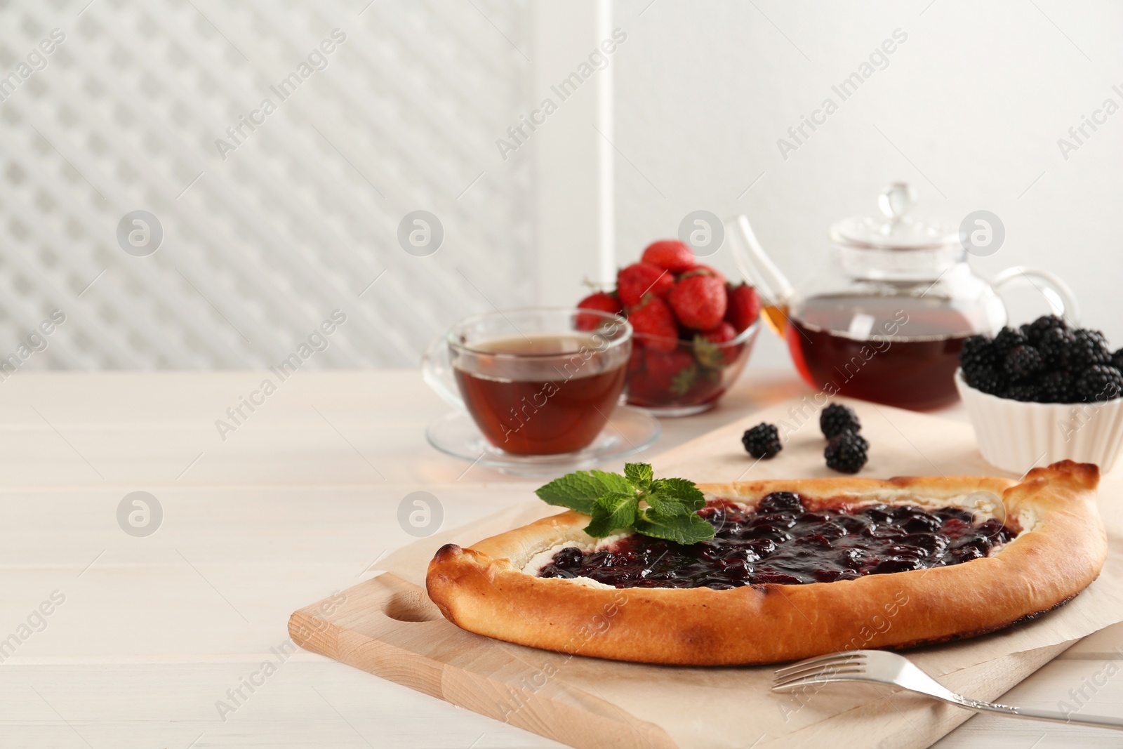 Photo of Delicious sweet cottage cheese pastry with cherry jam served on white wooden table. Space for text