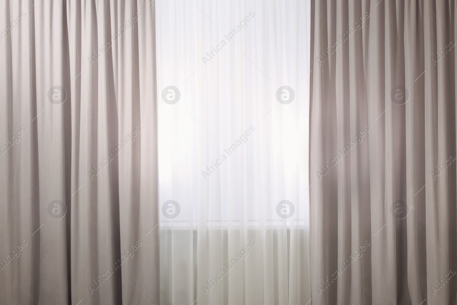 Photo of Light grey window curtains and white tulle indoors