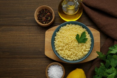 Tasty couscous and ingredients on wooden table, flat lay. Space for text