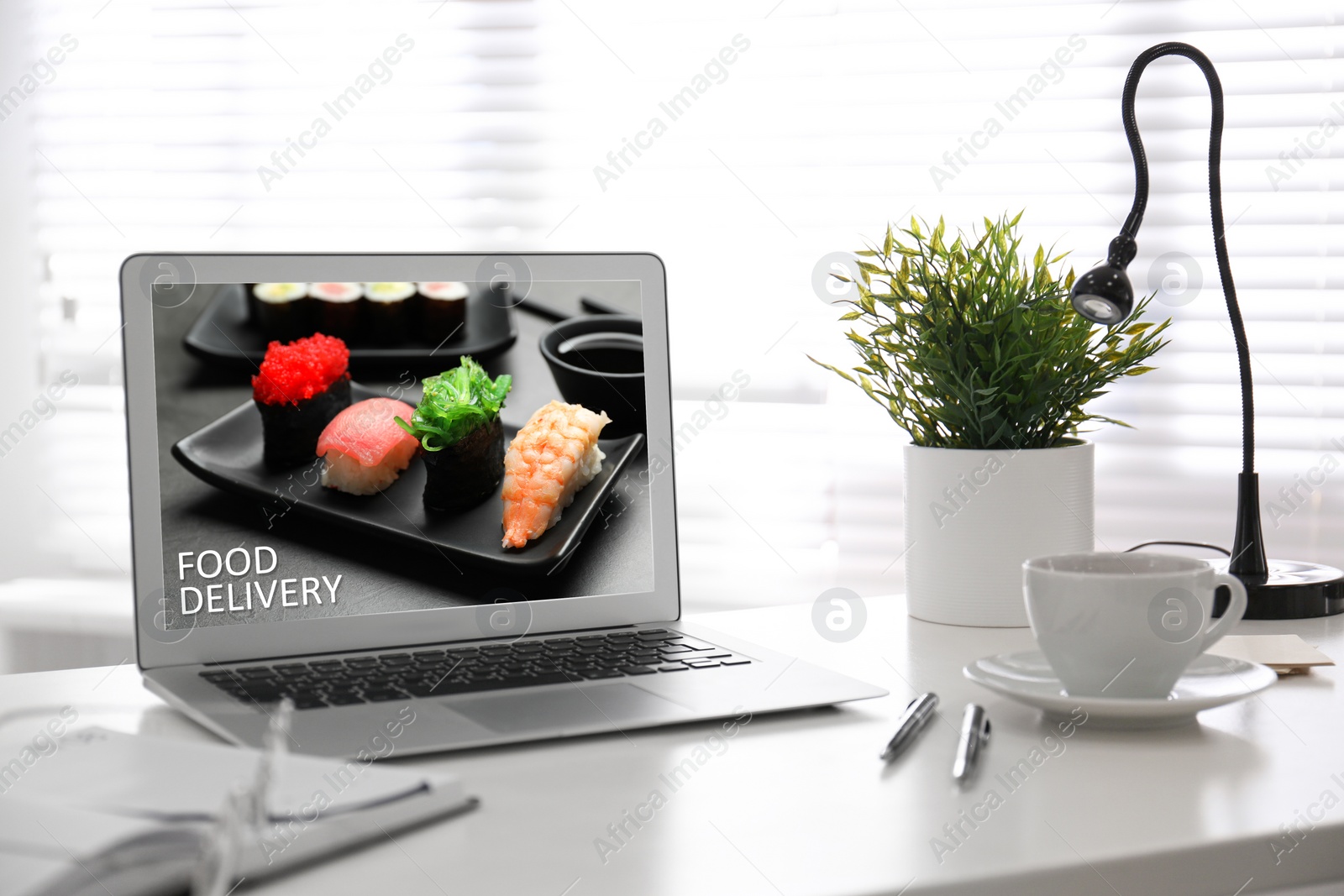 Image of Modern laptop with open page of food delivery service on screen
