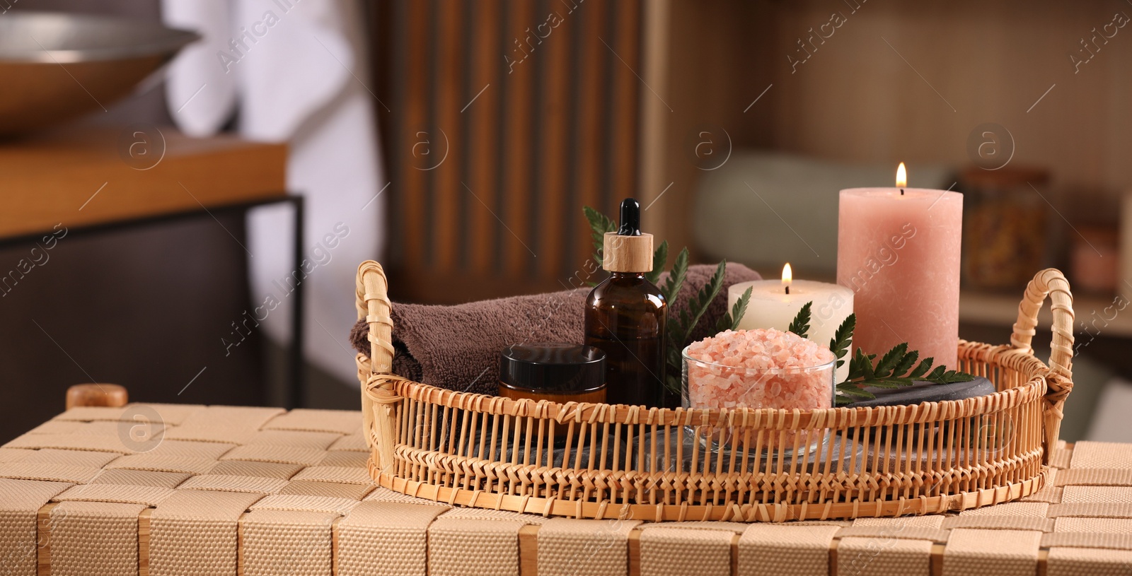 Photo of Beautiful composition with different spa products on wicker bench indoors, space for text