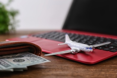 Photo of Composition with airplane model and laptop on wooden table. Travel agency concept