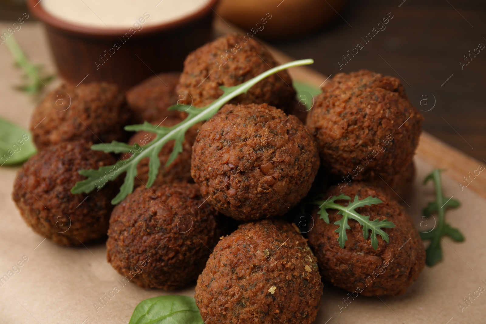 Photo of Delicious falafel balls and arugula on table, closeup