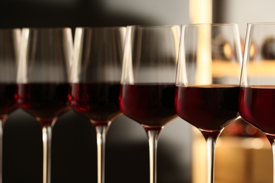 Photo of Glasses of red wine in cellar, closeup. Expensive drink