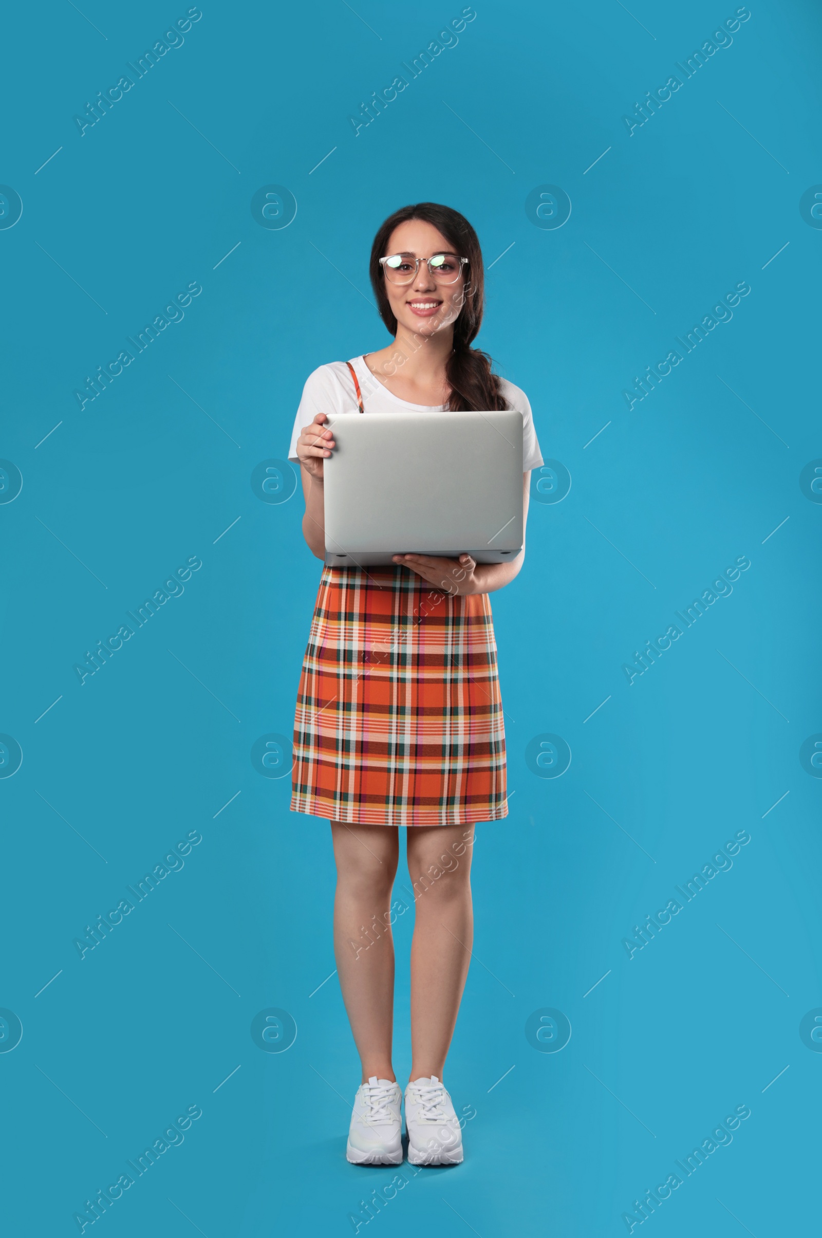 Photo of Young woman with laptop on blue background