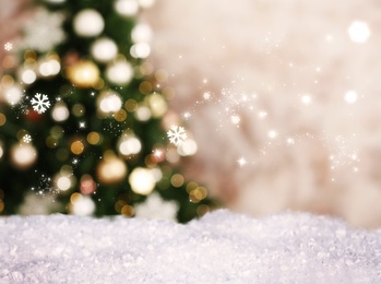 Image of Snow and blurred view of beautiful decorated Christmas tree. Bokeh effect