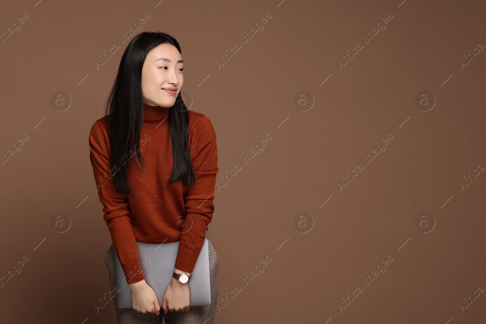 Photo of Portrait of beautiful woman with laptop on brown background. Space for text