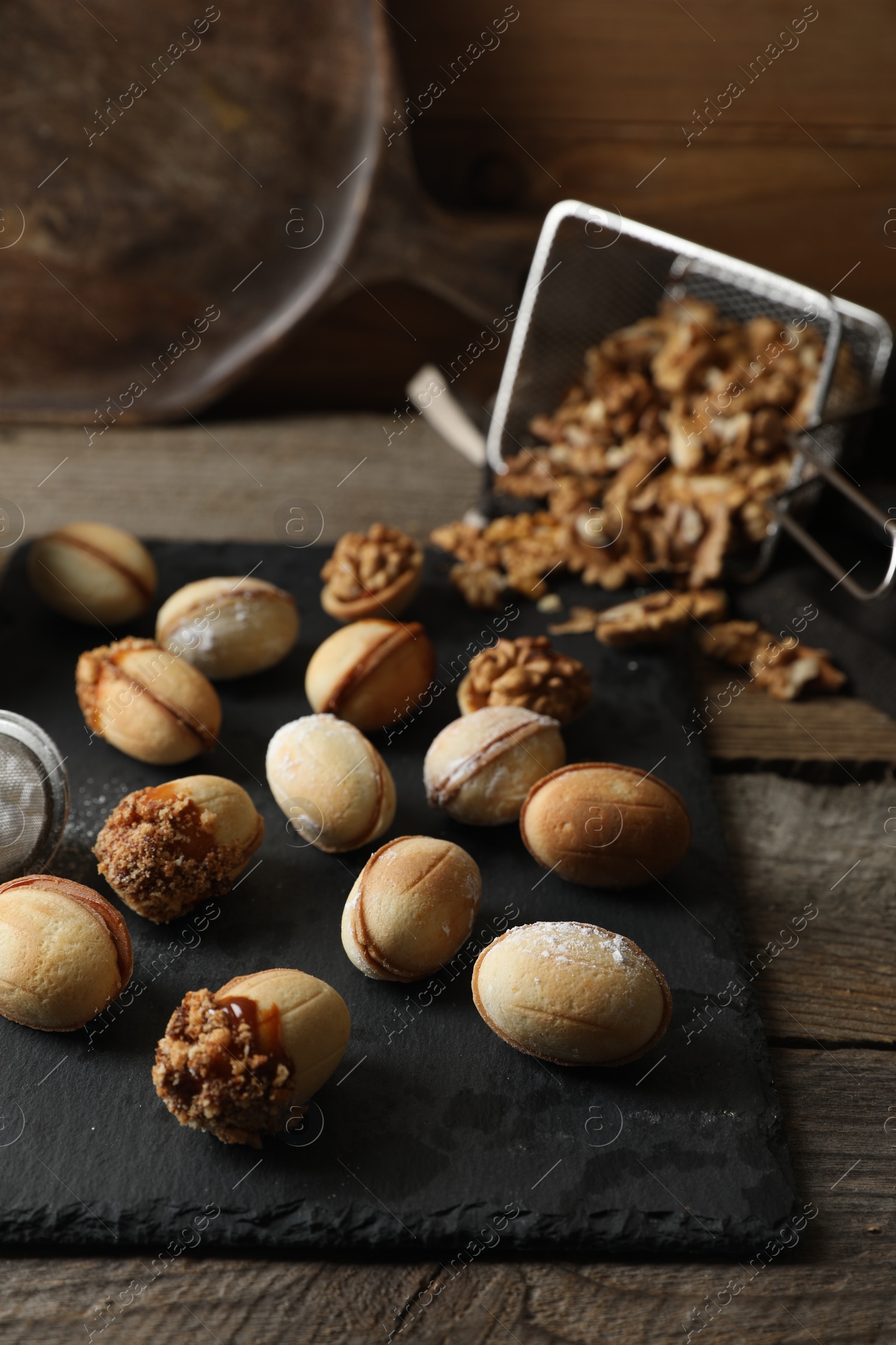 Photo of Freshly baked homemade walnut shaped cookies on wooden table