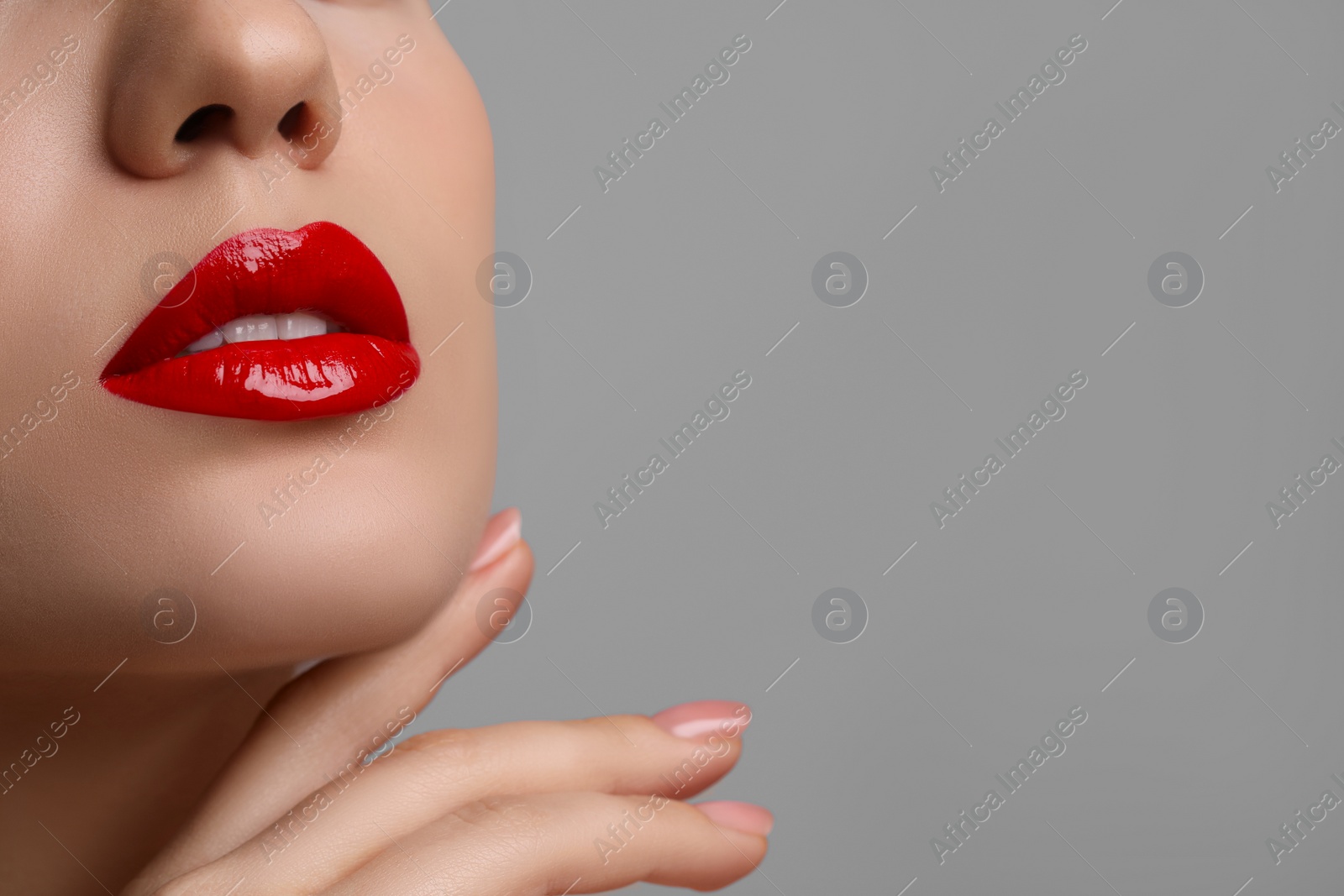 Photo of Closeup view of woman with beautiful full lips on grey background. Space for text