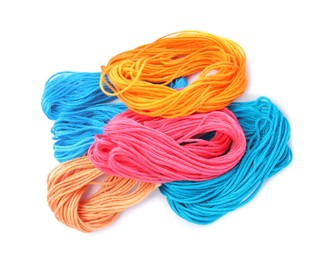 Different colorful embroidery threads on white background, top view