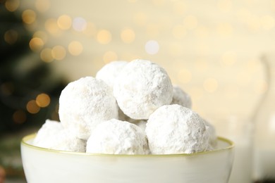 Tasty snowball cookies in light bowl, closeup, Christmas treat