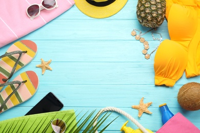 Photo of Flat lay composition with beach accessories on light blue wooden background, space for text