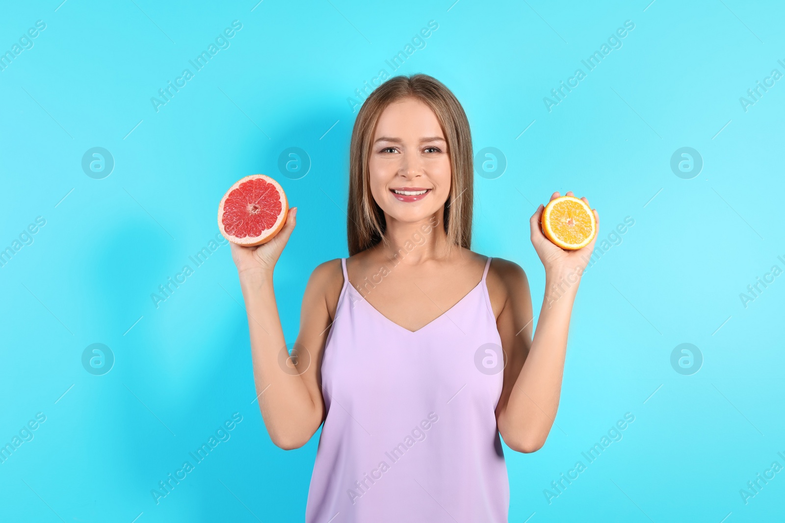 Photo of Slim woman with citrus fruits on color background. Healthy diet