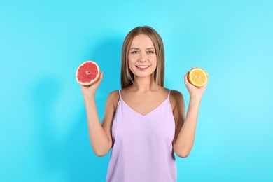 Photo of Slim woman with citrus fruits on color background. Healthy diet