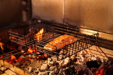 Photo of Grilling basket with salmon fillet in oven, closeup