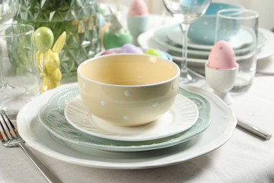 Photo of Easter celebration. Festive table setting with elegant dishware and painted eggs