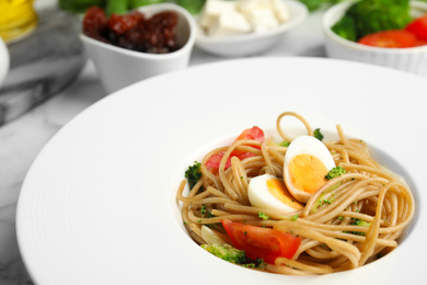 Photo of Tasty buckwheat noodles in plate on table, closeup