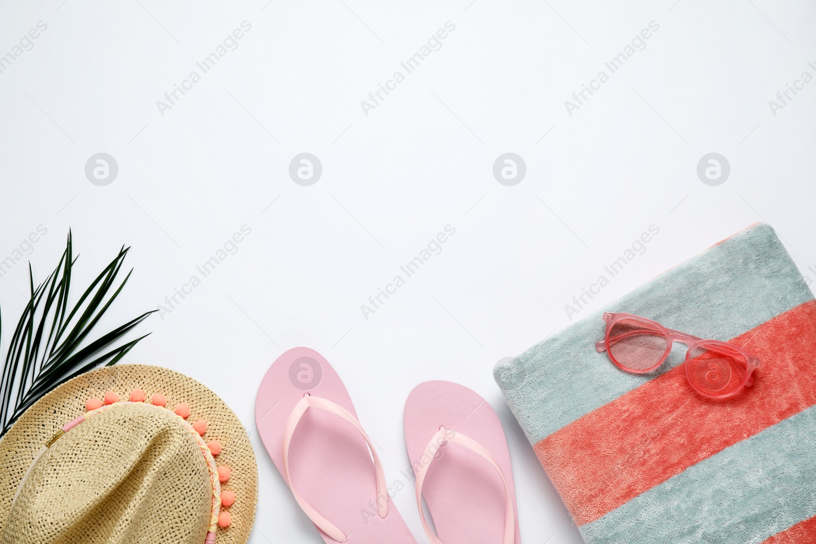 Photo of Beach towel, flip flops, hat and sunglasses on white background, flat lay. Space for text