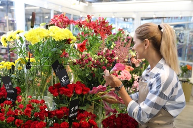 Photo of Beautiful female florist working in flower shop
