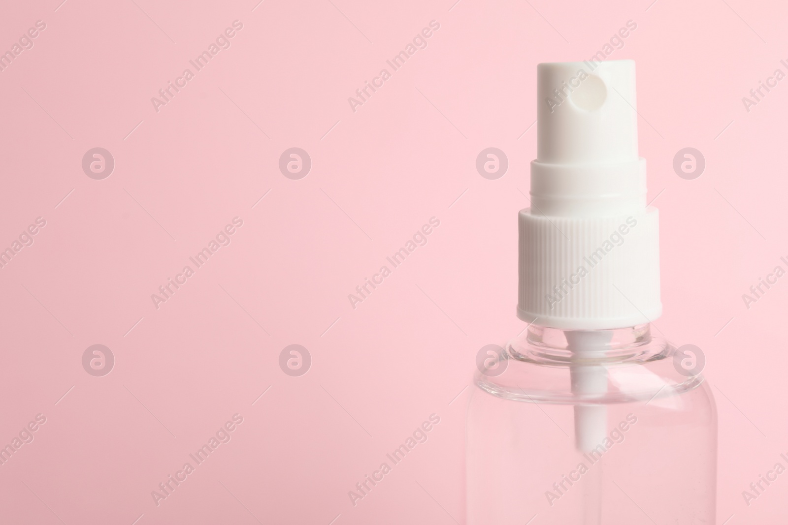 Photo of Antiseptic spray on pink background, closeup. Space for text