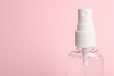 Photo of Antiseptic spray on pink background, closeup. Space for text