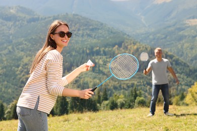 Couple playing badminton in mountains on sunny day