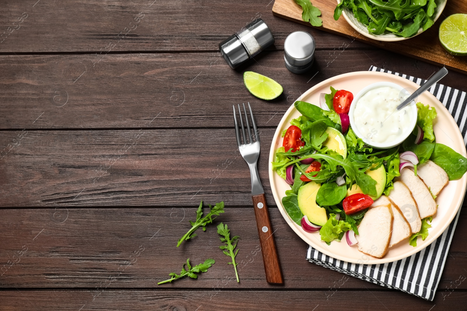 Photo of Delicious salad with chicken, arugula and avocado on wooden table, flat lay. Space for text