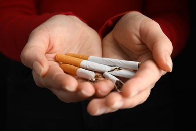 Photo of Woman with cigarettes on black background, closeup. Quitting smoking concept
