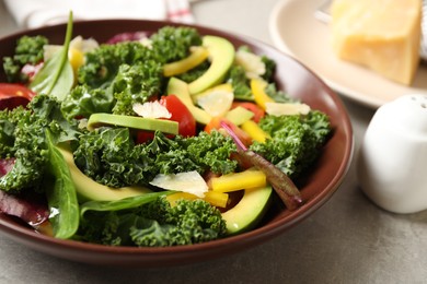 Photo of Tasty fresh kale salad on light grey table, closeup