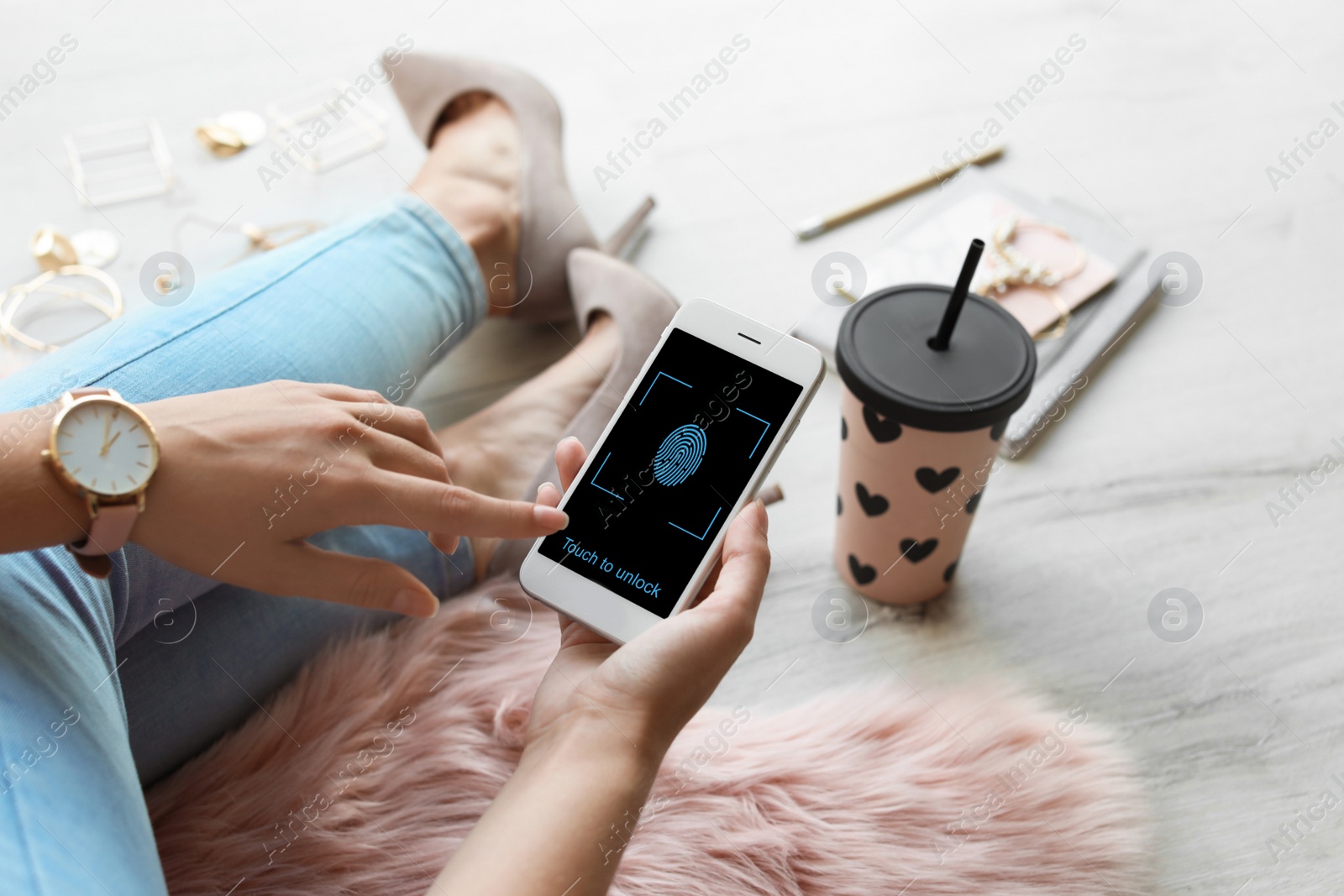 Image of Woman holding smartphone with fingerprint sensor indoors, closeup. Digital identity