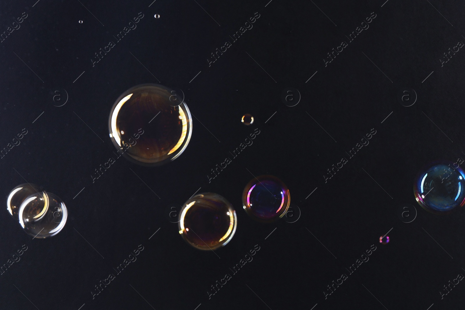 Photo of Beautiful transparent soap bubbles on dark background