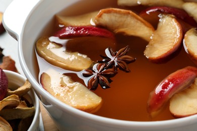 Delicious compote with dried apple slices and anise in pot, closeup