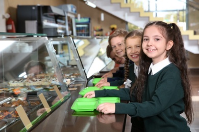 Photo of Children near serving line with healthy food in school canteen