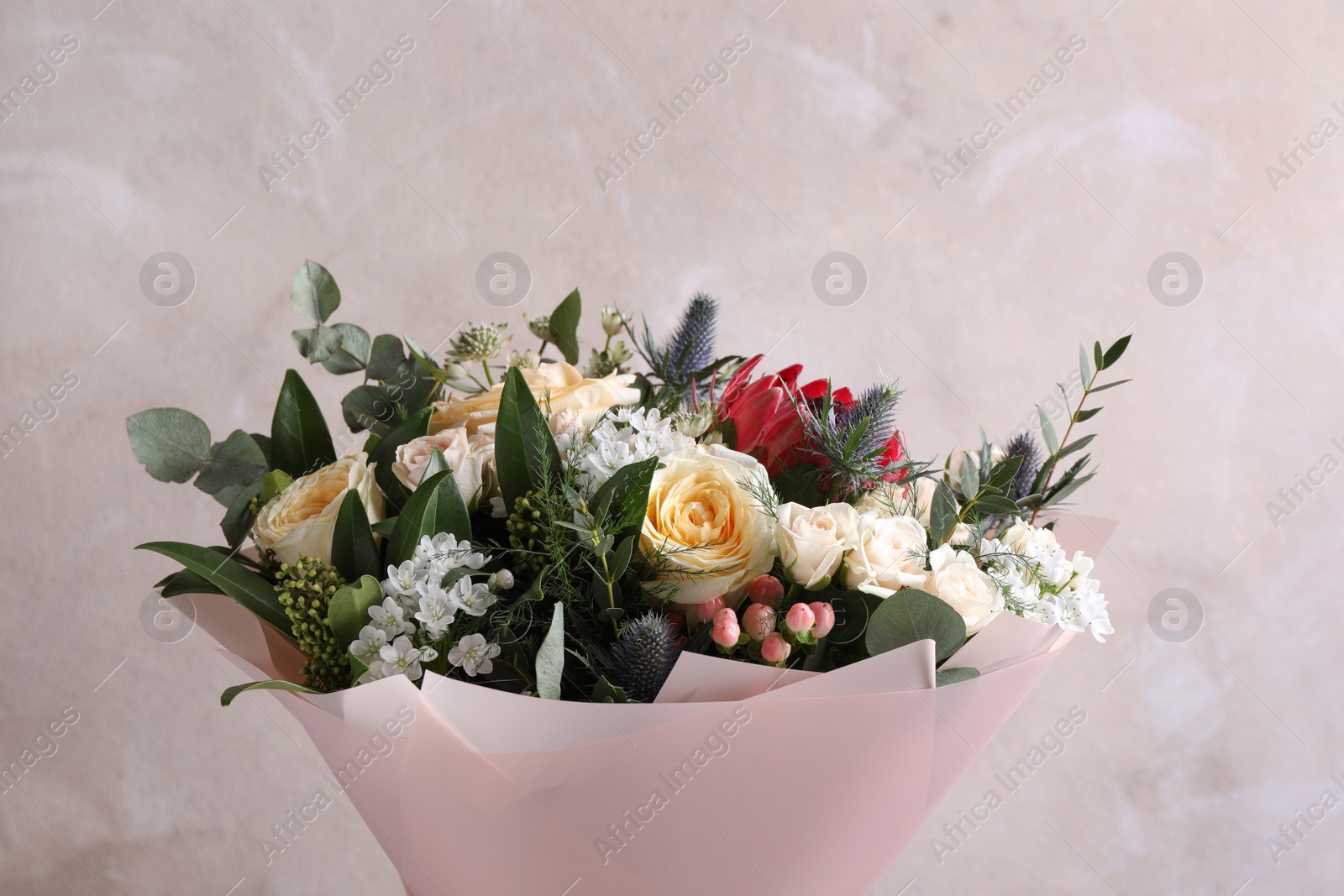 Photo of Beautiful bouquet with roses on beige background