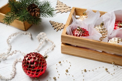 Composition with beautiful Christmas baubles on white wooden table