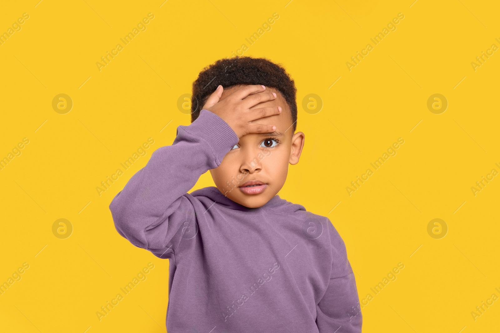 Photo of Portrait of emotional African-American boy on yellow background