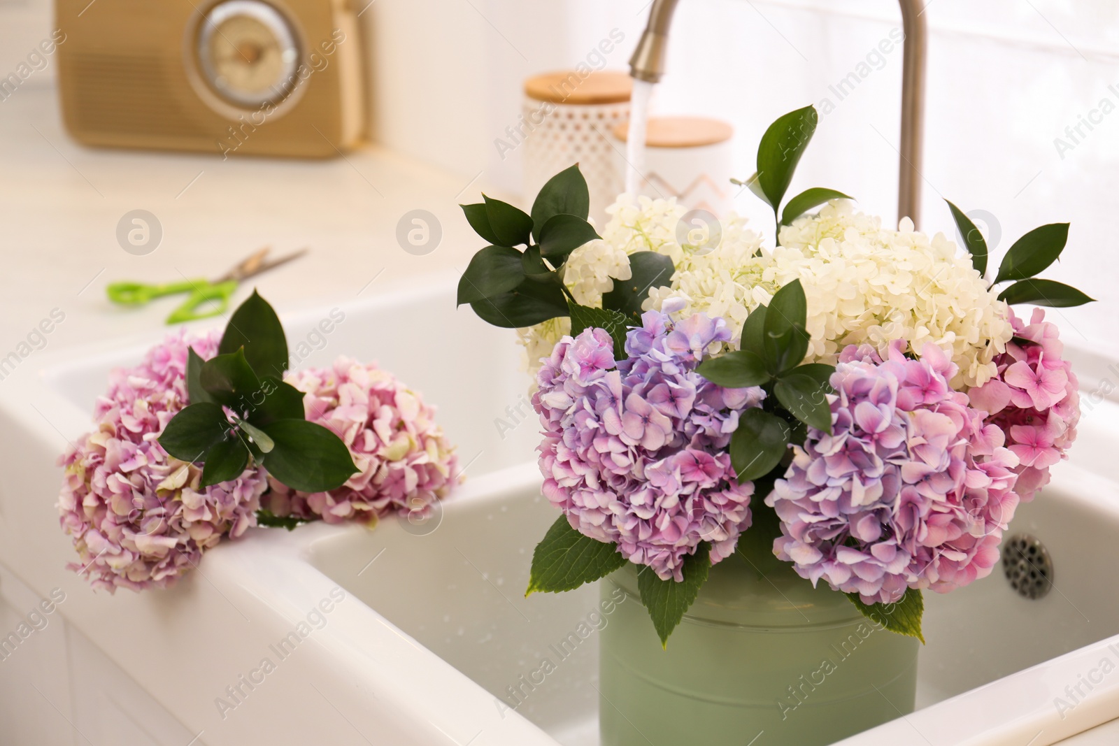 Photo of Bouquet with beautiful hydrangea flowers in sink, closeup