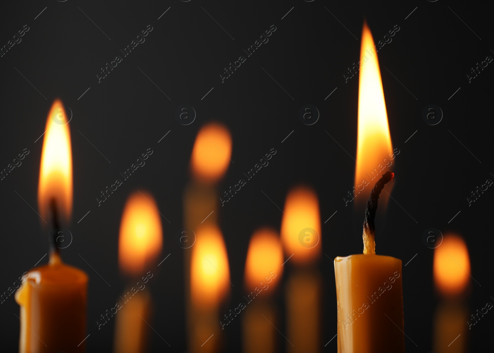 Photo of Burning candles on dark background, space for text. Symbol of sorrow