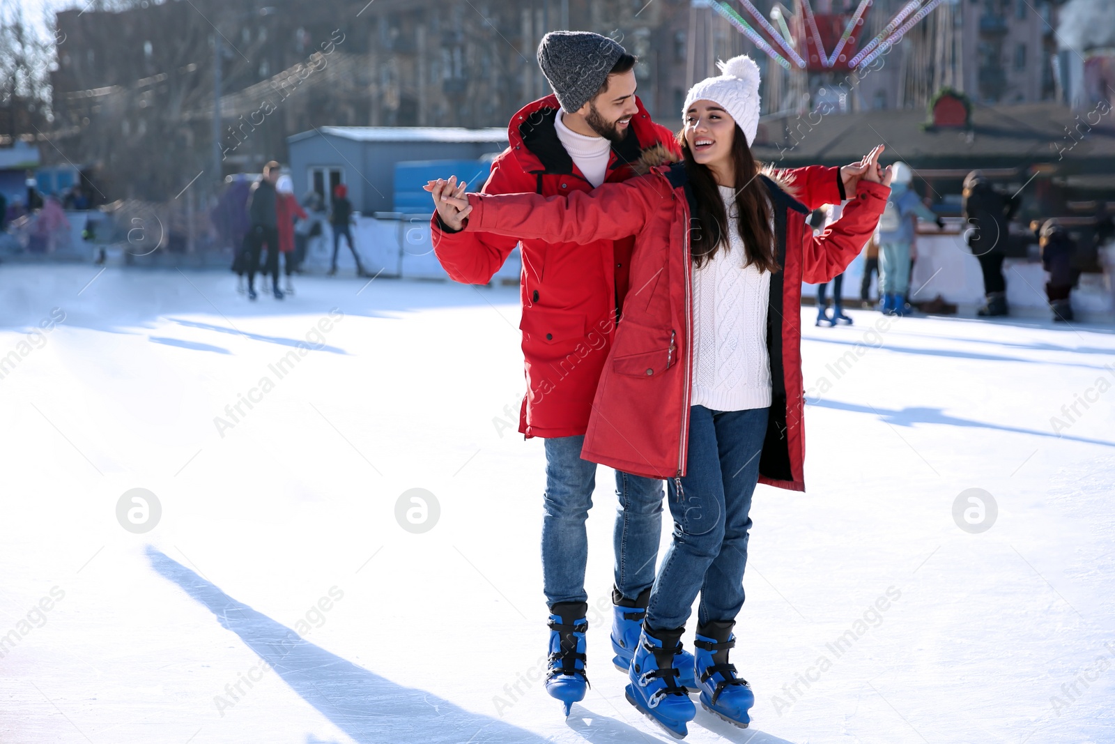 Image of Lovely couple spending time together at outdoor ice skating rink