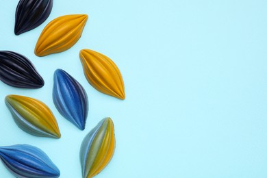 Photo of Tasty chocolate candies on light blue background, flat lay. Space for text