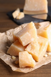 Pieces of delicious parmesan cheese on wooden table, closeup