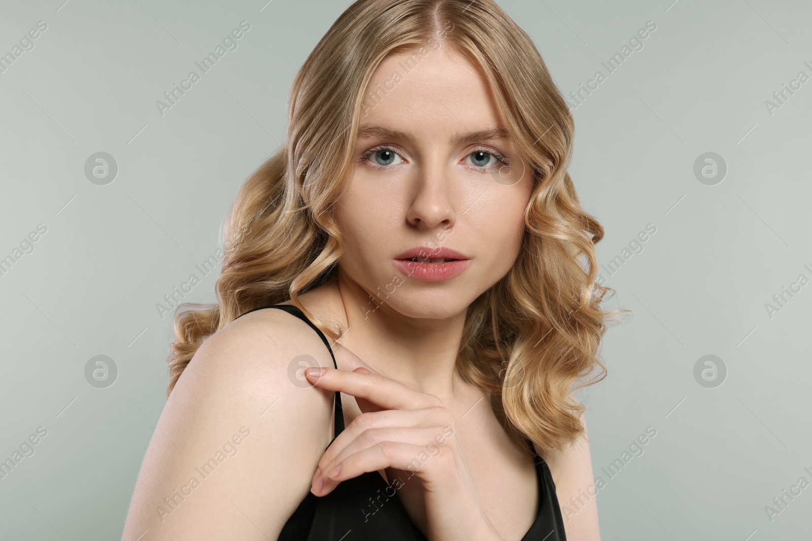 Photo of Portrait of beautiful woman with blonde hair on light grey background
