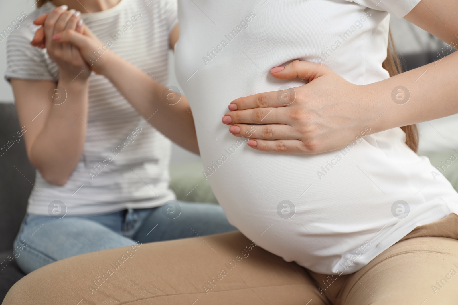 Photo of Doula taking care of pregnant woman indoors, closeup. Preparation for child birth