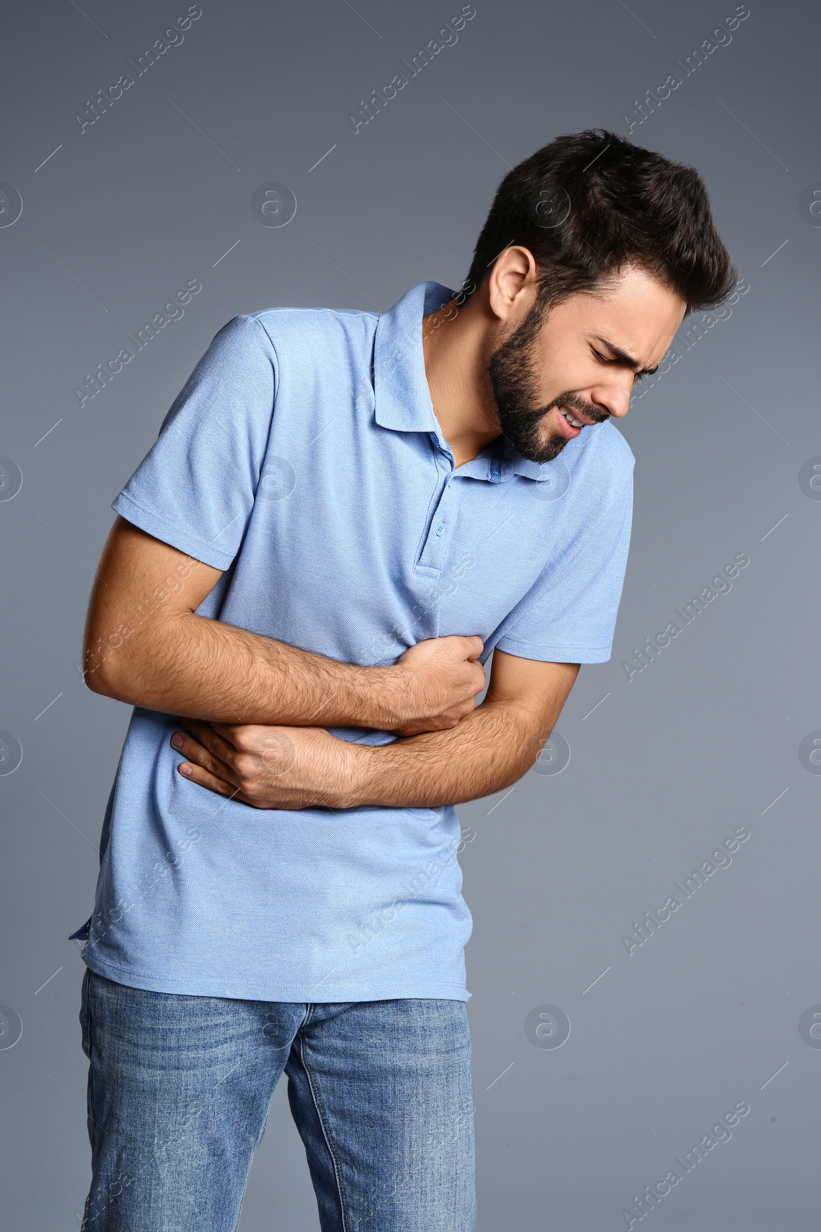 Photo of Man suffering from stomach pain on grey background