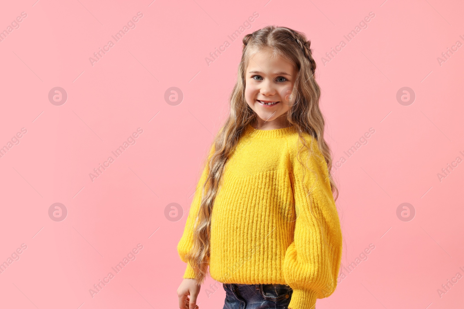 Photo of Cute little girl with braided hair on pink background. Space for text