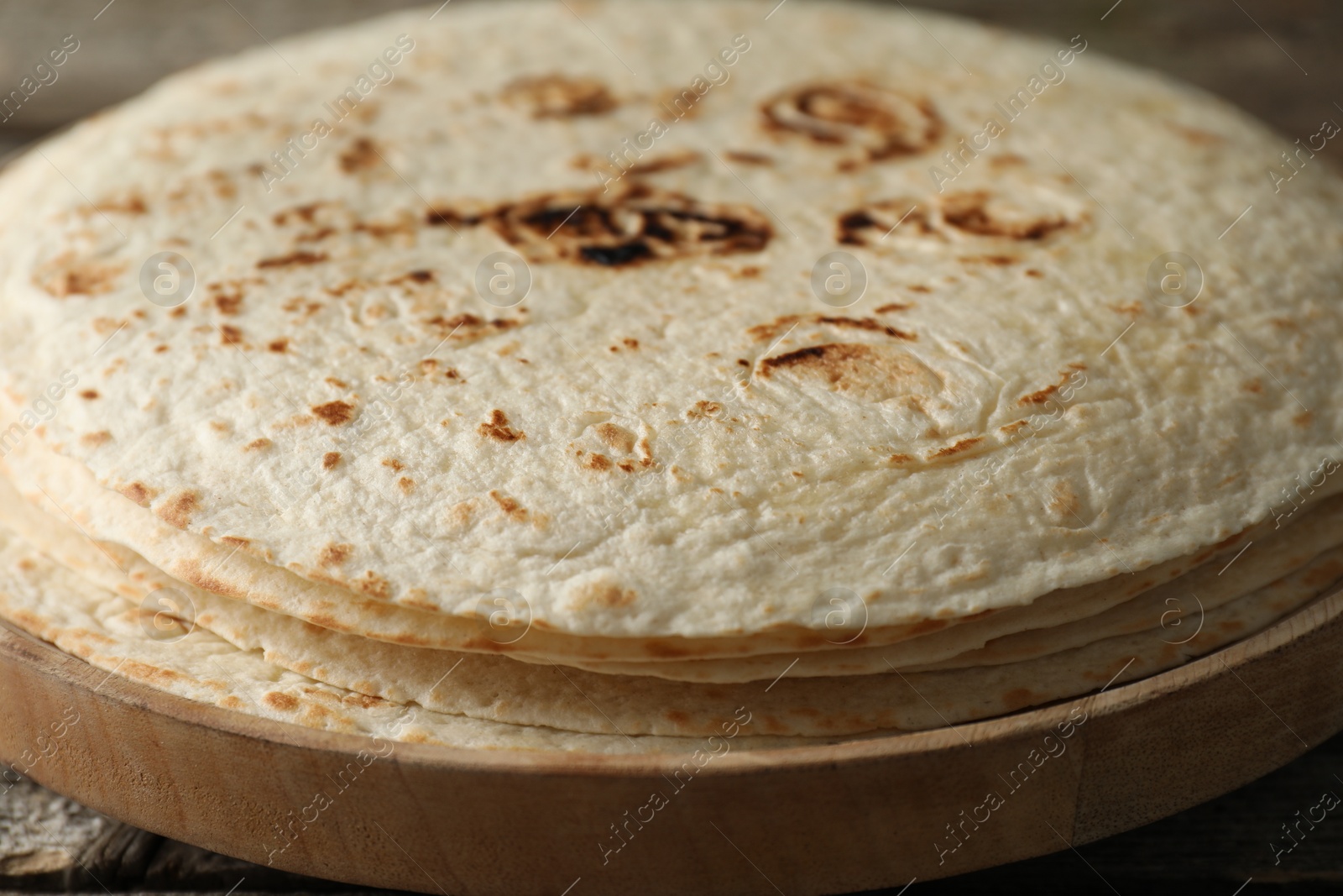 Photo of Stack of tasty homemade tortillas on table, closeup